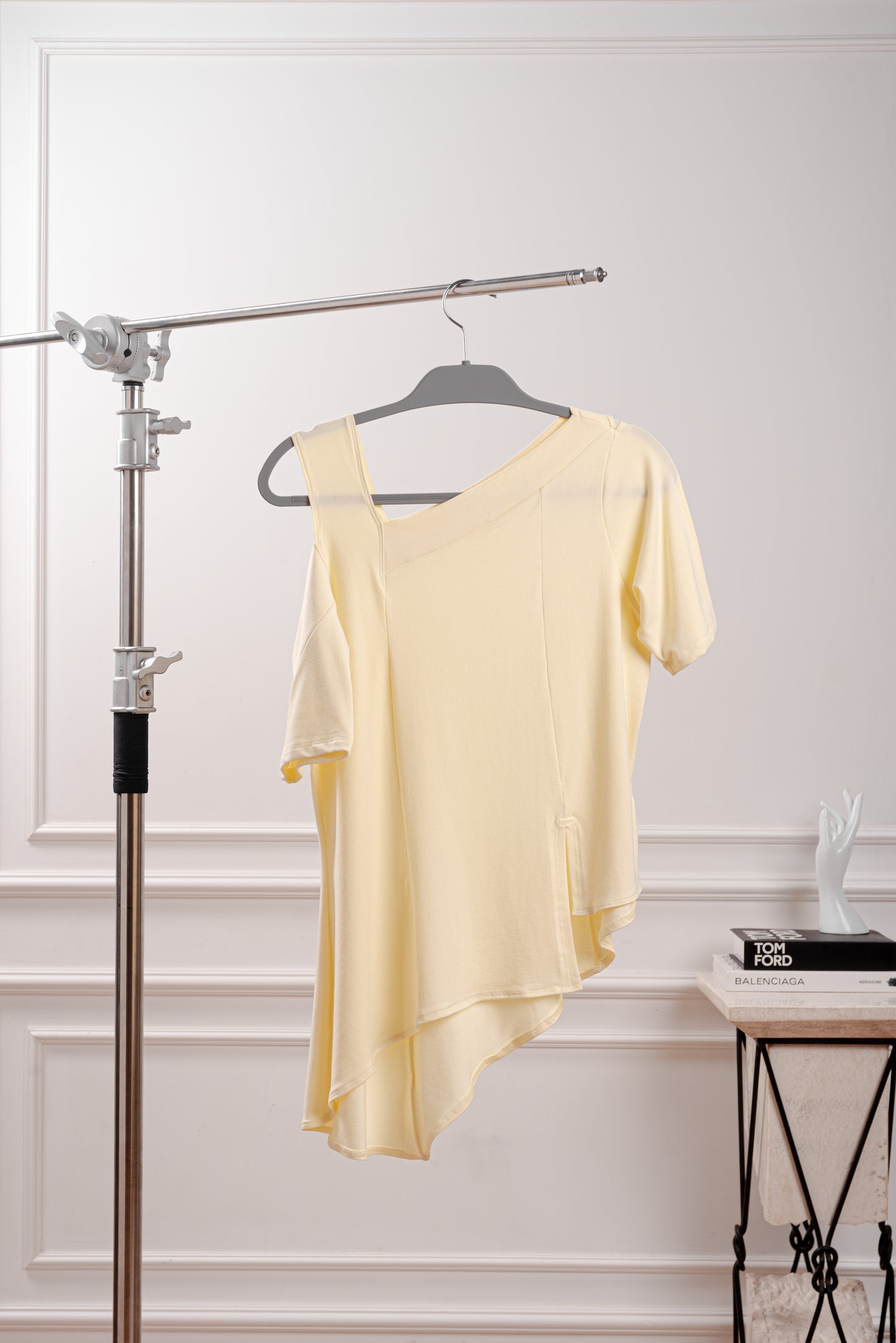 Polo Asimétrico con Hombro Descubierto, color amarillo mantequilla, siguiendo el trend butter yellow, con elegante contraste para un look minimalista. Detalle del Rib que atraviesa el hombro y la franja sin costura del polo asimétrico. Primer plano de la textura suave y transpirable del tejido Pima Modal, diseñado para la silueta Ovalada.