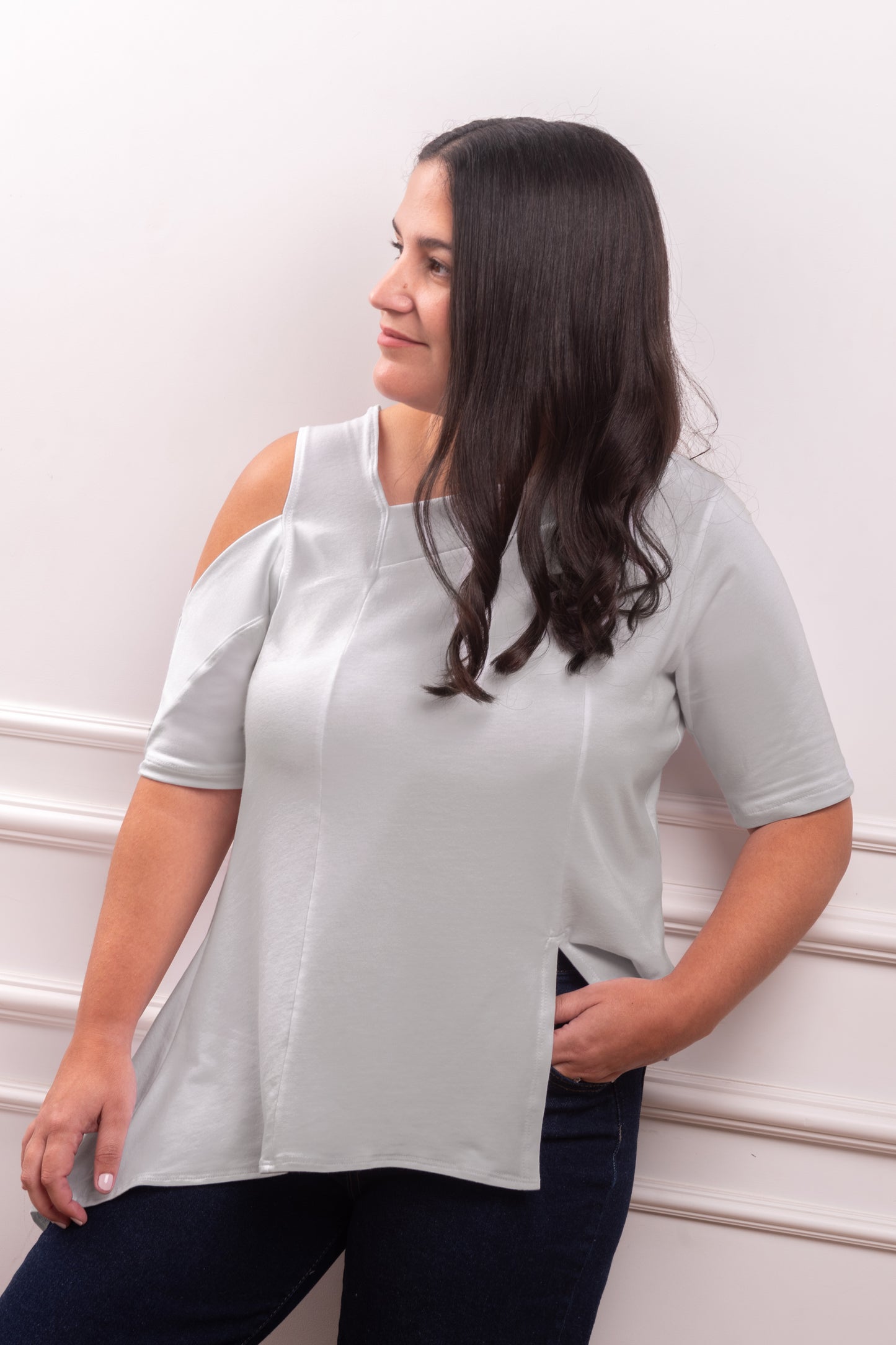 Polo Asimétrico con Hombro Descubierto, color gris, elegante contraste para un look minimalista. Detalle del Rib que atraviesa el hombro y la franja sin costura del polo asimétrico. Primer plano de la textura suave y transpirable del tejido Pima Modal, diseñado para la silueta Ovalada.